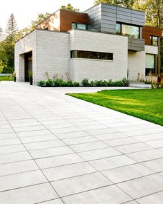 a large white brick house sitting on top of a lush green field