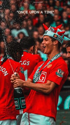 a group of men in red shirts standing next to each other with water pouring from their heads