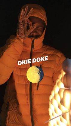 a man in an orange jacket with the words okie doke written on it