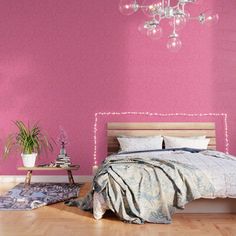 a bedroom with pink walls and wooden flooring has a chandelier hanging from the ceiling