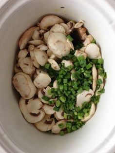 mushrooms and green onions in a white bowl