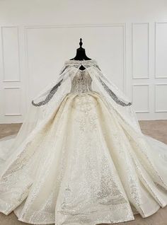 a wedding dress on display in a white room