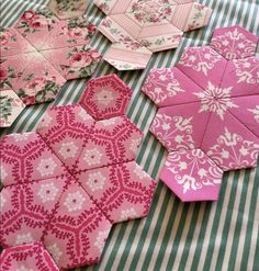 several pink and white hexagonals laid out on a green striped tablecloth