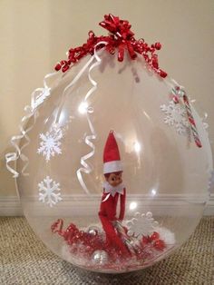 an elf is sitting in a large bubble ball with snowflakes on the bottom