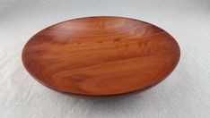 a wooden bowl sitting on top of a white table