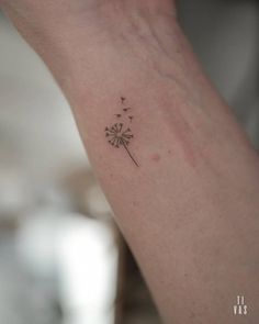 a small dandelion tattoo on the wrist