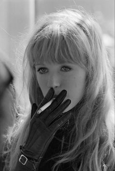 a black and white photo of a woman wearing gloves