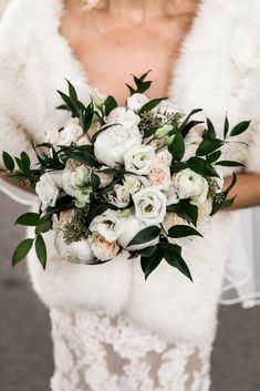 a woman in a white wedding dress holding a bridal bouquet