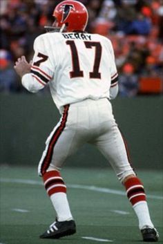 a football player in action on the field with his hand out to throw the ball