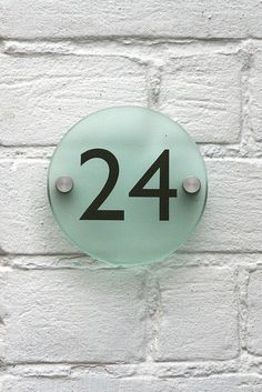 the number twenty four is attached to a white brick wall