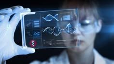 a woman in white lab coat holding up a piece of glass with images on it