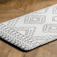 a white and black rug sitting on top of a wooden floor