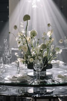 a glass table topped with lots of white flowers