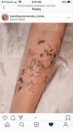 a woman's arm with flowers and bees on it