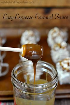 caramel sauce being poured into a jar with marshmallows in the background