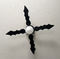 a black and white clock mounted to the side of a wall with bats on it