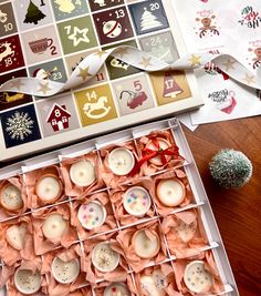 a box filled with lots of different types of candles next to a christmas tree and other decorations