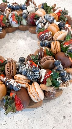 a wreath made out of chocolate covered macaroons, strawberries and other pastries