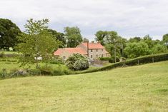 a house in the middle of a lush green field