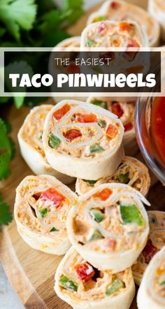 some taco pinwheels on a cutting board with ketchup