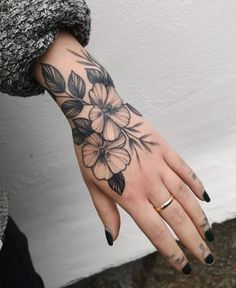 a woman's hand with black and white flowers on it