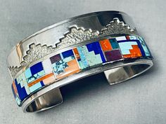 "MAKE US AN OFFER BY CLICKING THE \"MESSAGE SELLER\" Button- This is an amazing Navajo inlaid silver cuff bracelet. This fascinating bracelet contains a remarkable inlaid section that borders the bottom portion of the cuff. The inlay includes Royston turquoise, spiderweb turquoise stones, coral, pink coral, lapis, mother of pearl, and sugulite. Bordering the other edge of the cuff are outsanding deep silver geometric patterns with a textured background. I absolutely love that the ends of the cuf Luxury Southwestern Bracelets With Inlay, Luxury Sterling Silver Inlay Bracelet As Gift, Unique Luxury Bracelets With Inlay, Luxury Turquoise Bracelets With Inlay, Turquoise Silver Bracelet, Navajo Bracelet, Navajo Turquoise, Royston Turquoise, Silver Line