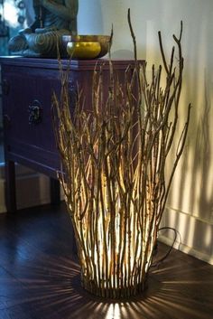 a vase with some branches in it sitting on a wooden floor next to a dresser