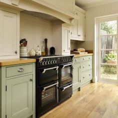 a kitchen with green cabinets and an oven