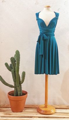 a dress on a mannequin next to a cactus