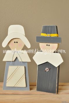 two wooden peg dolls are standing next to each other