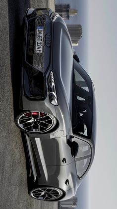 the rear end of a silver sports car with its hood up and wheels down, seen from above