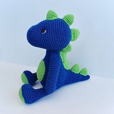 a crocheted blue and green toy sitting on top of a white table next to a wall