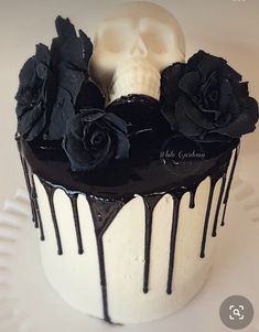 a cake decorated with black and white icing, roses and a skull on top