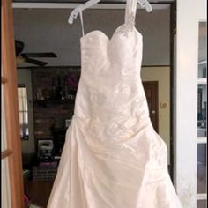 a white wedding dress hanging on a rack