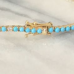 "This finely handcrafted \"Tennis Bracelet\" is composed of 14K solid gold set with AAA quality round cabochon cut genuine natural real Turquoise gemstones and accented with GVs1 quality natural real Diamonds. This classic bracelet is finished with a secure snap lock closure and double security clasps for safety. The setting and mounting quality is guaranteed for everyday wear. ♦ Bracelet Length: 7 inches (can be customized in length upon request) ♦ Bracelet Width: 2.15 mm ♦ Metal Finish: High S Elegant Single Strand Turquoise Bracelet, Opal Birthstone Ring, Eternity Bracelet, Opal Birthstone, Snap Lock, Topaz Engagement Ring, Real Turquoise, Classic Bracelets, Diamond Tennis Bracelet