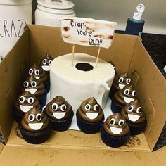 cupcakes with googly eyes are sitting in a cardboard box next to a sign that says crap you're old