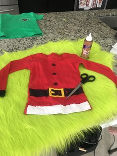 a santa clause outfit is laying on the counter next to some scissors and other items