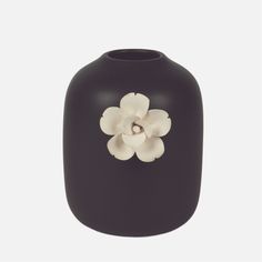 a black vase with a white flower on the front and bottom part of it's body