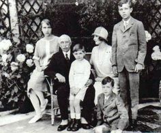 an old black and white photo of a family posing for a picture in the garden