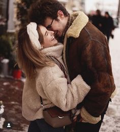 a man and woman are hugging in the snow