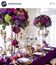 the table is set with purple and green flowers