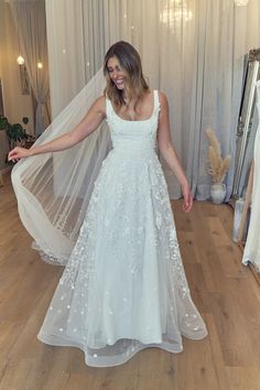 a woman in a white wedding dress is posing for the camera