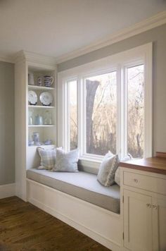 a white window seat with pillows on it