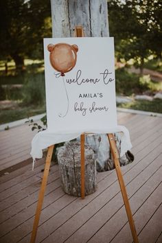 a welcome sign sitting on top of a wooden easel