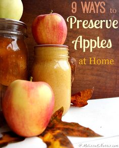 three jars filled with apples sitting next to each other on top of a wooden table