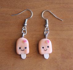 two little ice cream popsicle earrings with pink frosting on them