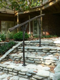 a stone walkway with a metal handrail in front of a house