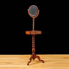 an old fashioned wooden stand with a mirror on it's top and two legs