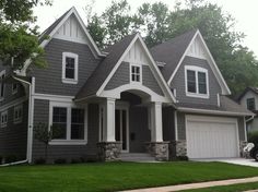 a gray house with white trim on the front and side windows is shown in this image