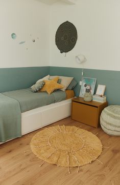 a bedroom with a bed, rug and pictures on the wall